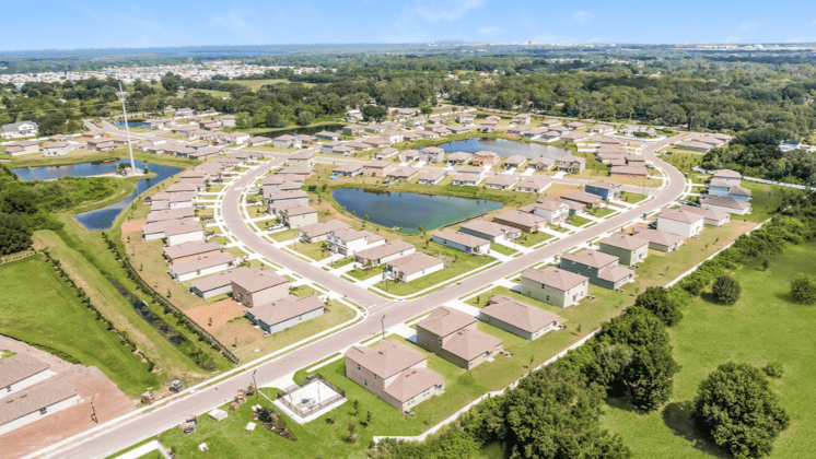 An arial shot of a community of single family homes spread around a couple of lakes surrounded by a lot of greenery.