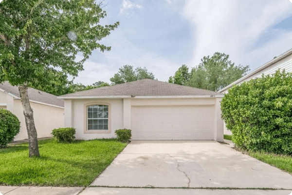 Exterior of home in Florida with tree and bushes Exterior of home in Florida with tree and bushes