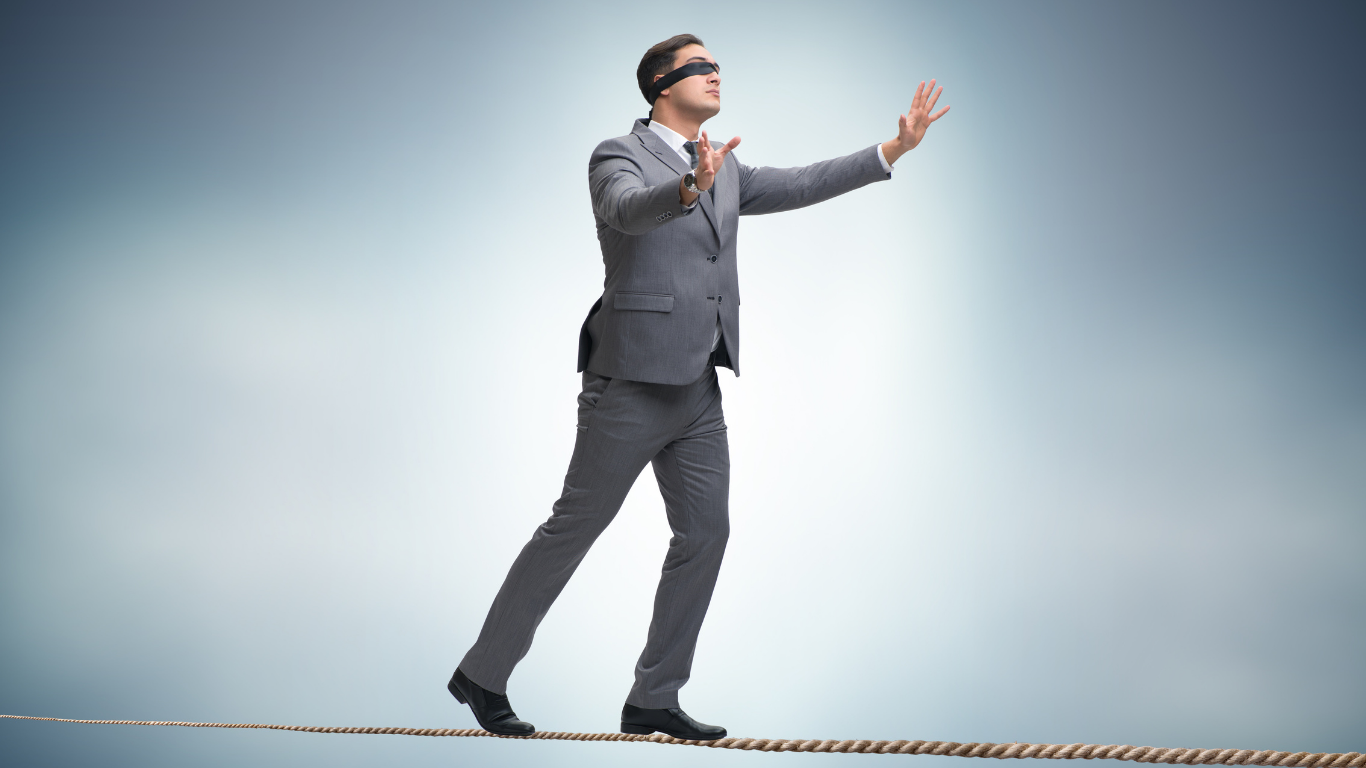 Man in a suit, upright, balancing himself on a tightrope.