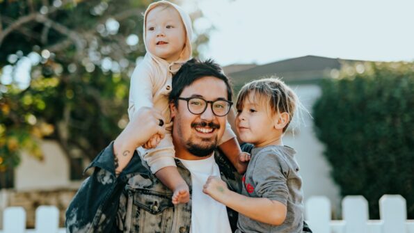 Man with two kids in front of home